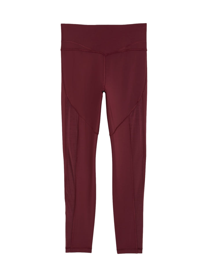 Mujer vistiendo leggings deportivos PUMA de color rojo vino, corte 7/8 y cintura alta.