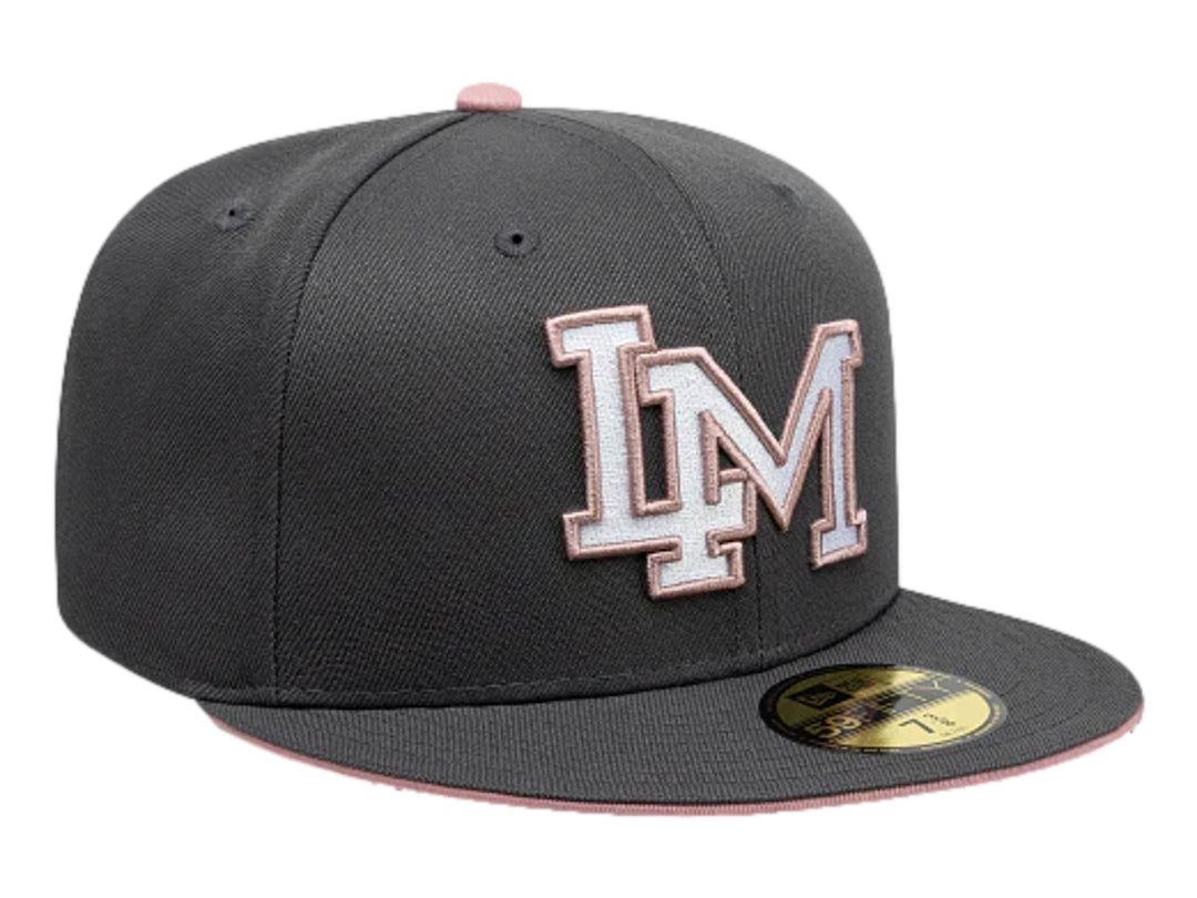Gorra New Era color gris oscuro con visera plana y letras bordadas en blanco y rosa en el frente.