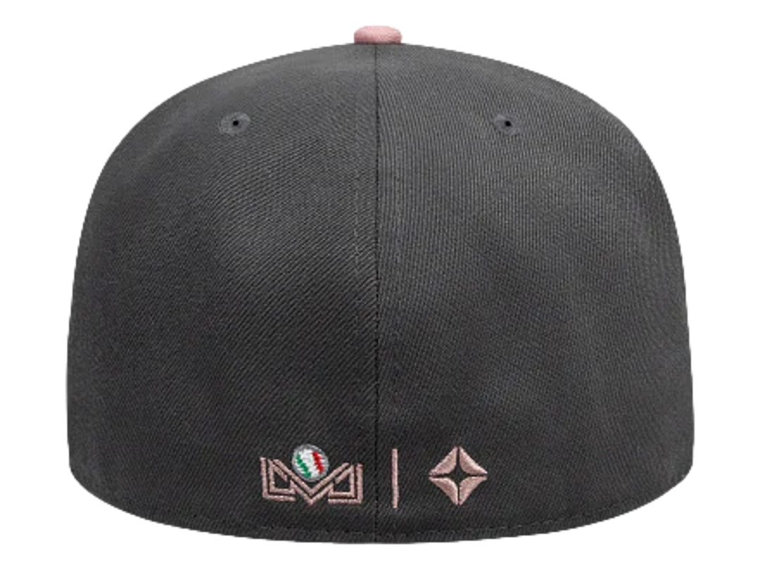 Gorra New Era color gris oscuro con visera plana y letras bordadas en blanco y rosa en el frente.