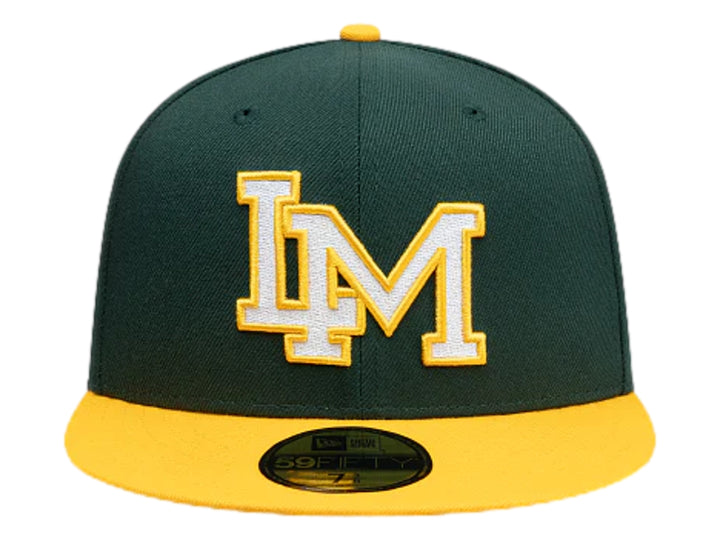 Gorra New Era color verde oscuro con visera amarilla y letra M bordada en blanco y amarillo al frente.