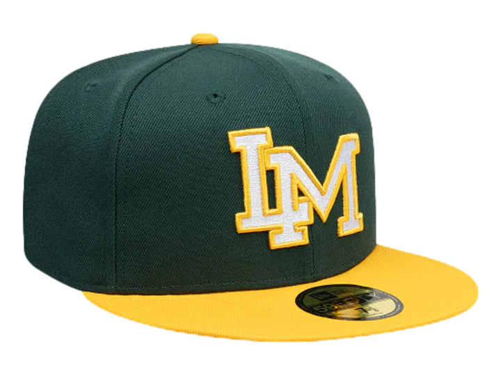 Gorra New Era color verde oscuro con visera amarilla y letra M bordada en blanco y amarillo al frente.