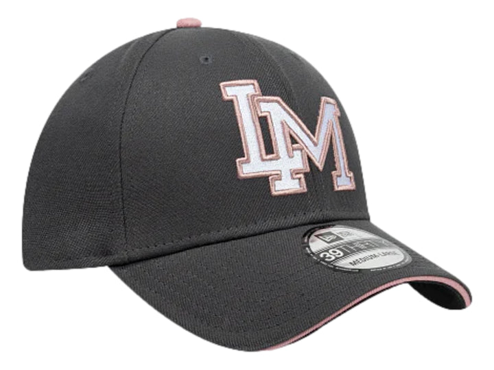 Gorra New Era color gris oscuro con letras bordadas en blanco y rosa en el frente y visera curva.