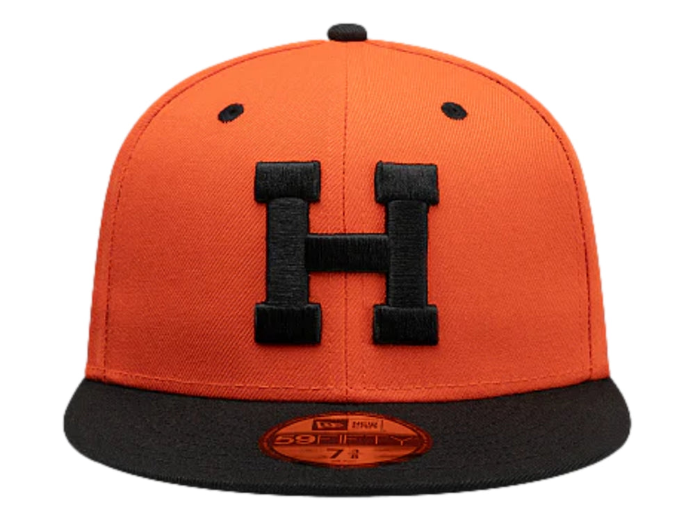 Gorra New Era color naranja con visera plana y logo frontal en color negro.