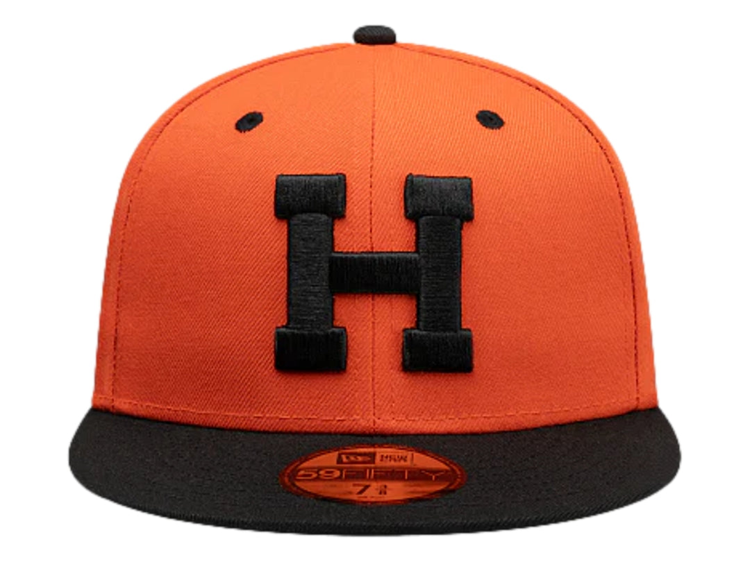 Gorra New Era color naranja con visera plana y logo frontal en color negro.