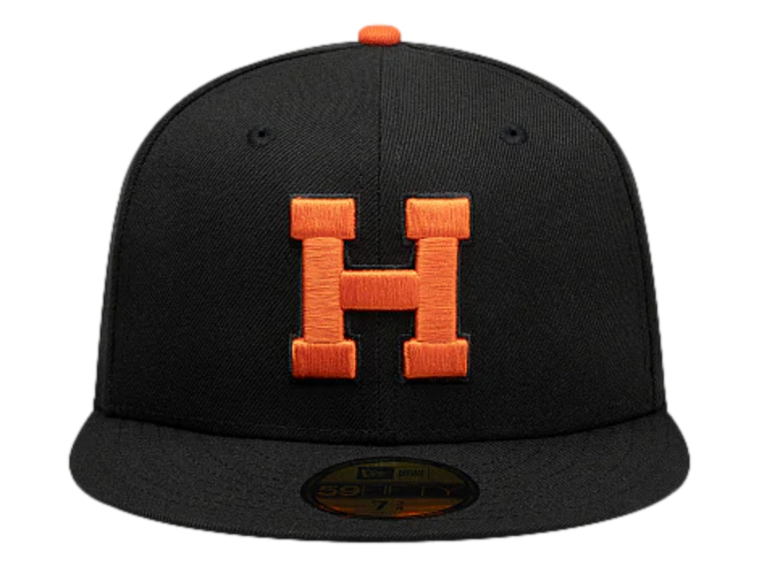 Gorra New Era color negro con logotipo bordado en naranja y visera plana.