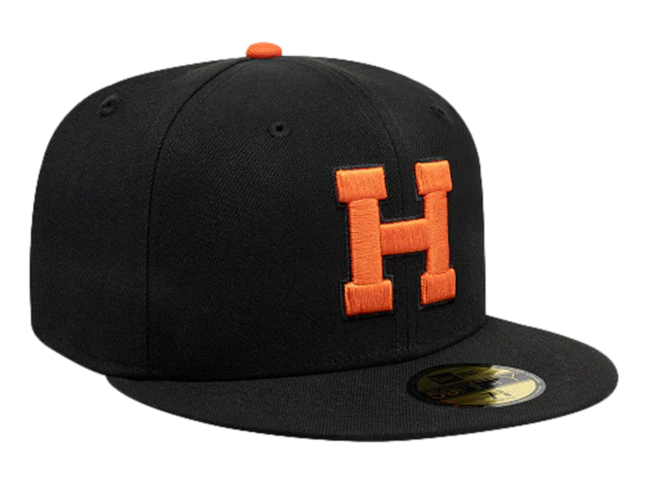 Gorra New Era color negro con logotipo bordado en naranja y visera plana.