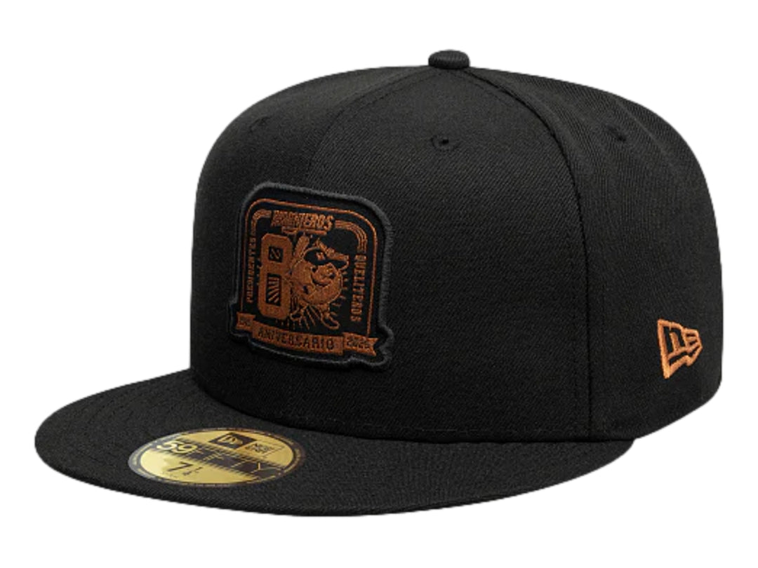 Gorra New Era negra con visera plana y logotipo bordado en color dorado en el frente.