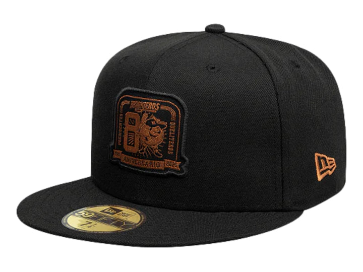 Gorra New Era negra con visera plana y logotipo bordado en color dorado en el frente.