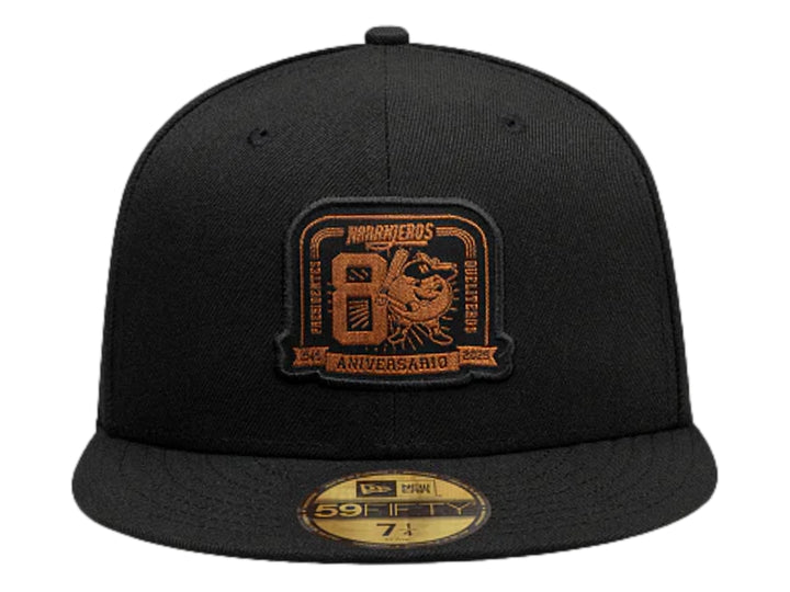 Gorra New Era negra con visera plana y logotipo bordado en color dorado en el frente.