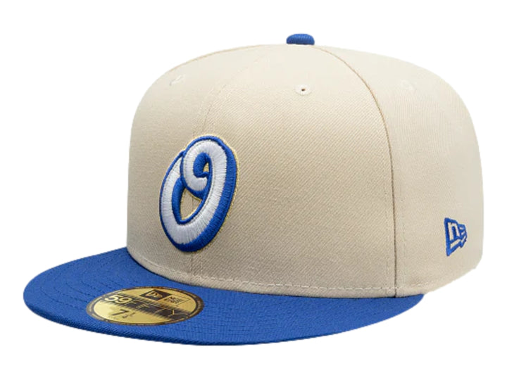 Gorra New Era color beige con visera azul y logotipo bordado en el frente.