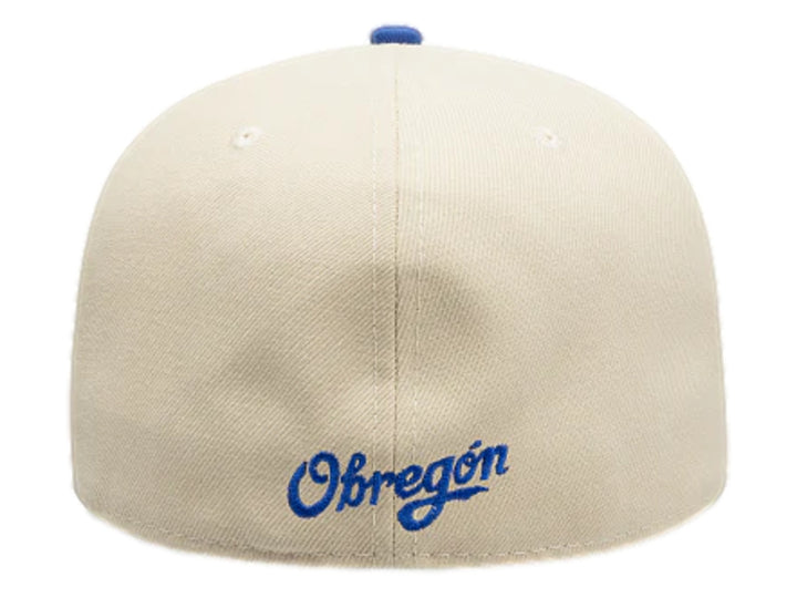 Gorra New Era color beige con visera azul y logotipo bordado en el frente.