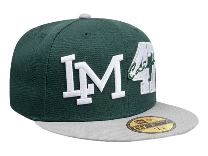 Gorra New Era color verde oscuro con visera gris y bordados blancos en el frente.
