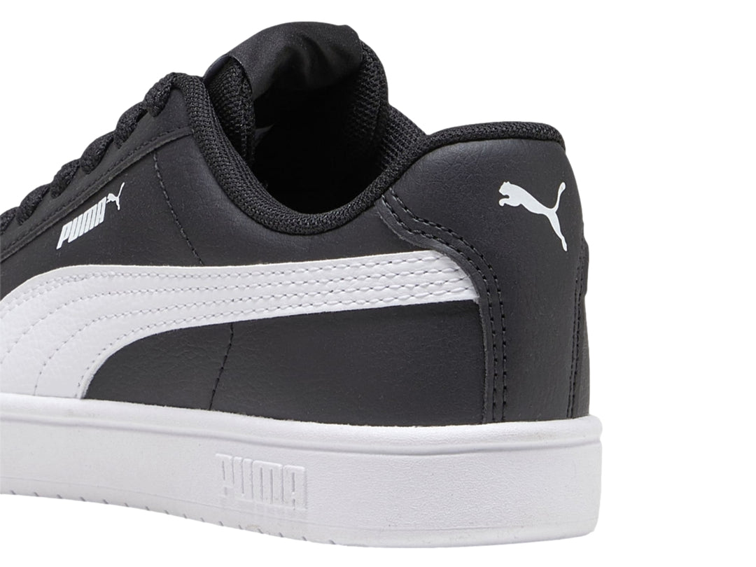 Tenis PUMA Rickie Classic JR en color negro con franja lateral y suela blanca.
