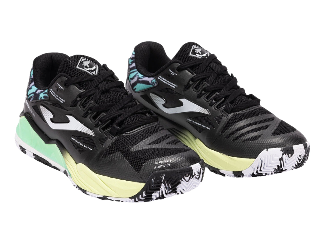Tenis deportivos Joma color negro con suela en degradado verde lima y detalles azules en el talón.