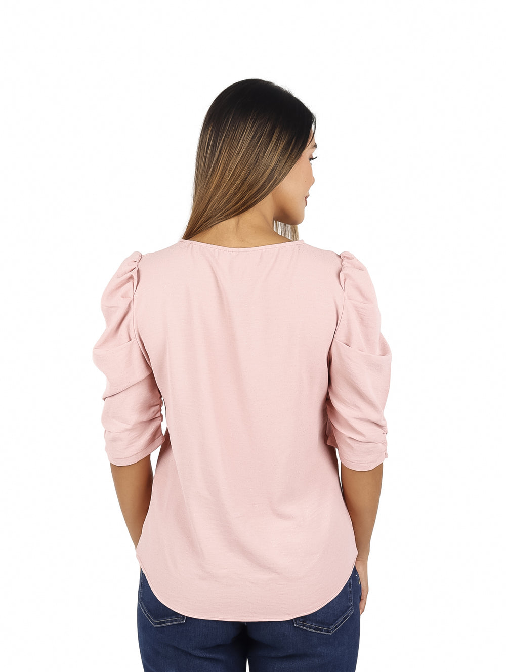 Mujer vistiendo una blusa rosa de manga 3/4 con cuello redondo y pantalones vaqueros azules.