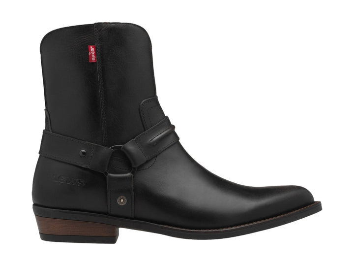 Bota negra de material sintético con correa y hebilla, suela marrón y etiqueta roja de marca.