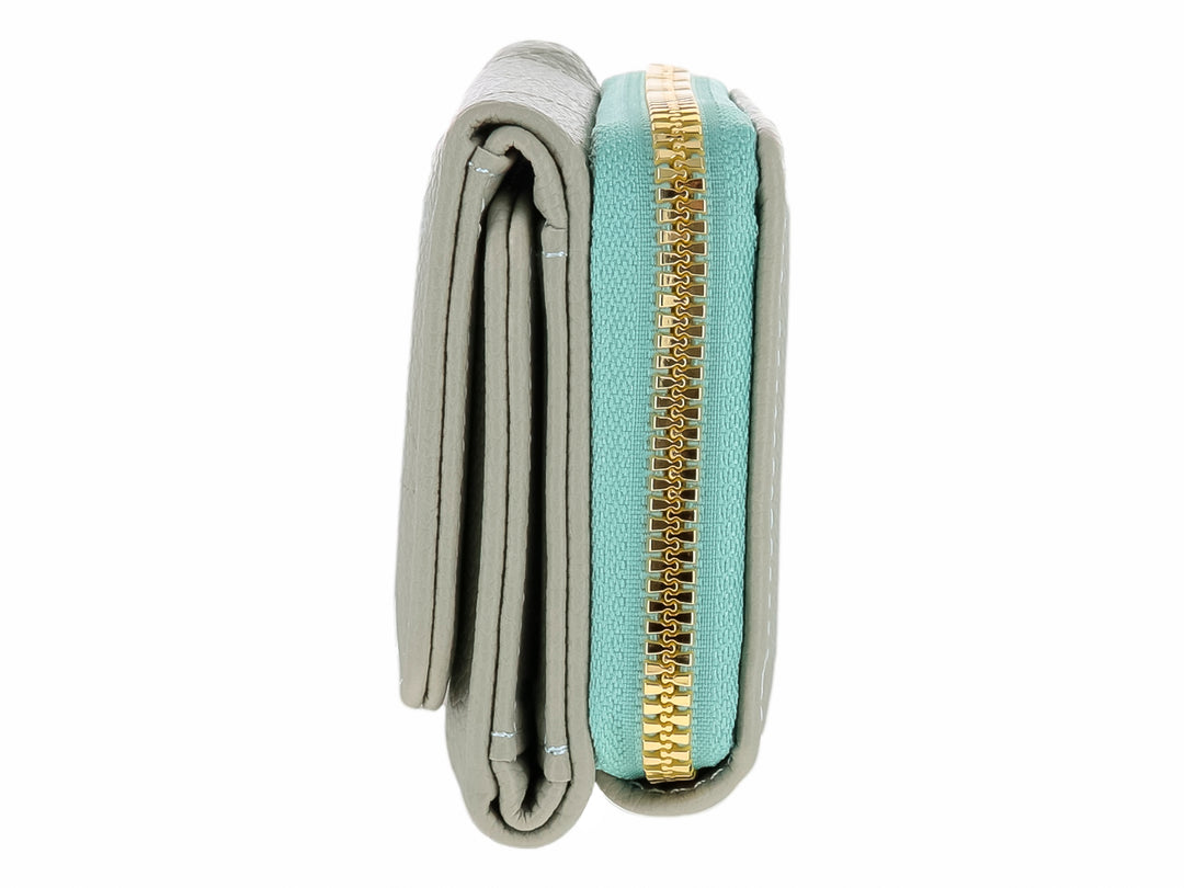 Monedero Felianna color verde con cierre superior dorado y un adorno metálico triangular en la solapa.
