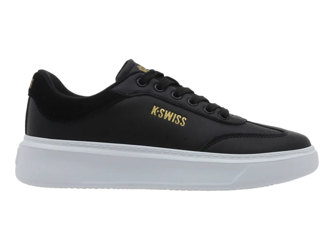 Tenis K-Swiss modelo Aldina en color negro con suela de plataforma blanca y logotipo dorado lateral.