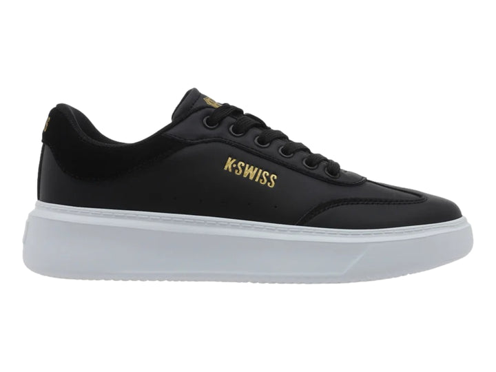 Tenis K-Swiss modelo Aldina en color negro con suela de plataforma blanca y logotipo dorado lateral.