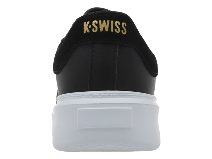 Tenis K-Swiss modelo Aldina en color negro con suela de plataforma blanca y logotipo dorado lateral.