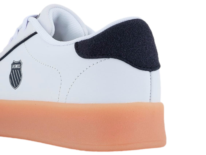 Tenis K-Swiss blancos con detalles en azul marino y gris, destacando una suela gruesa de color miel.