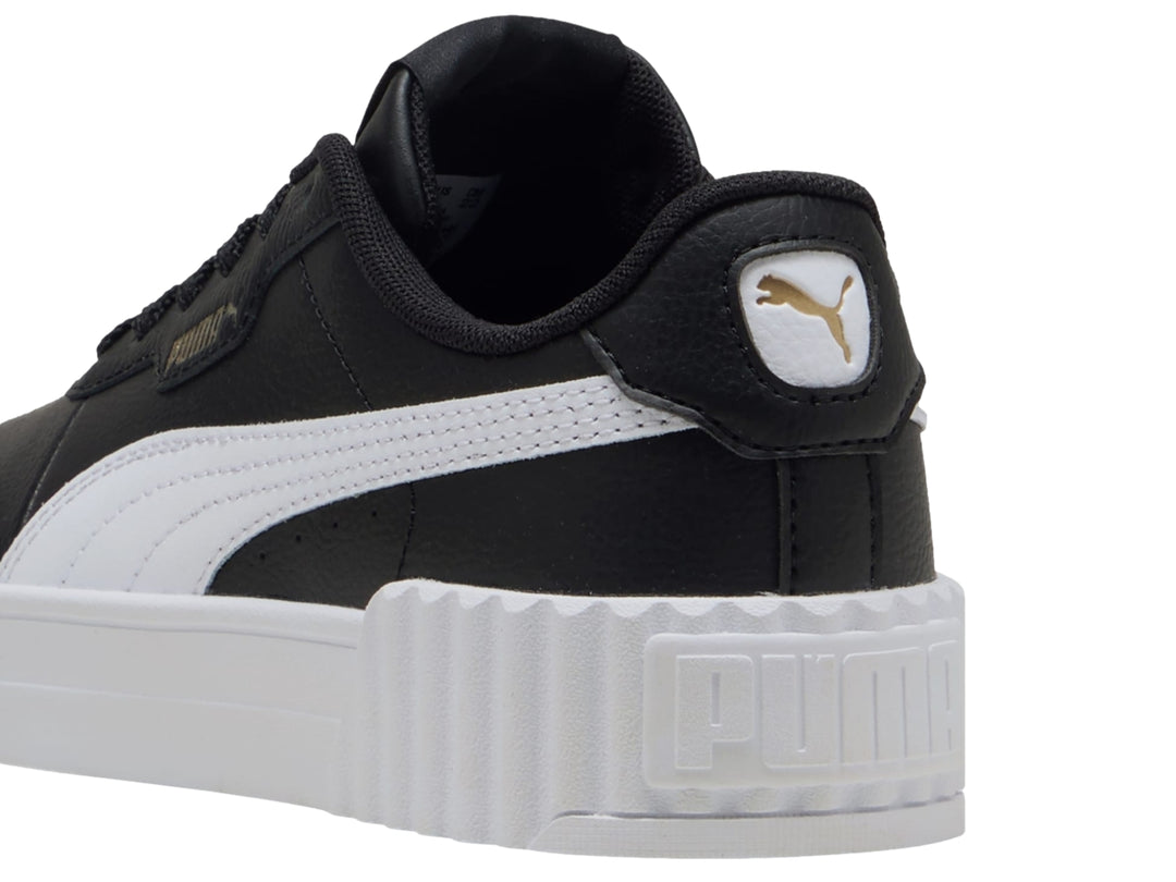 Tenis PUMA Carina 3.0 JR color negro con suela blanca de plataforma y detalles dorados.