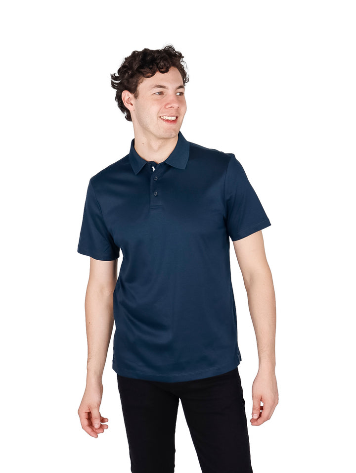 Hombre vistiendo una camiseta polo de color azul oscuro con cuello y manga corta.