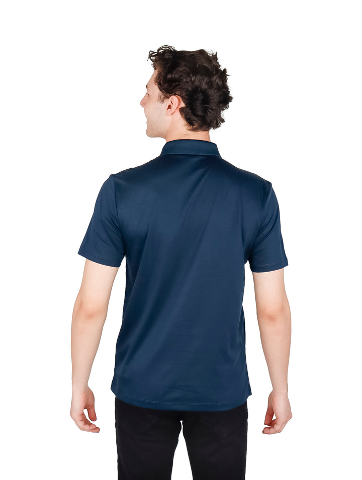 Hombre vistiendo una camiseta polo de color azul oscuro con cuello y manga corta.