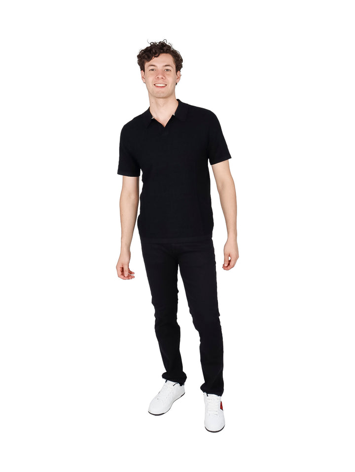 Hombre vistiendo una camiseta polo de manga corta color negro.