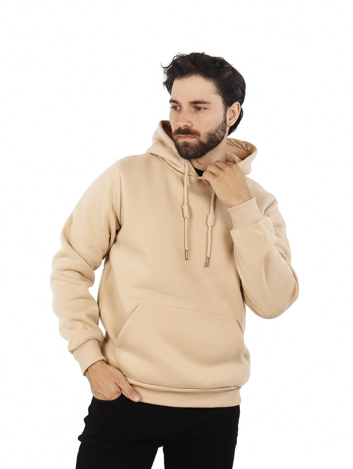 Hombre vistiendo sudadera con capucha color beige, con bolsillo frontal y ajuste casual.