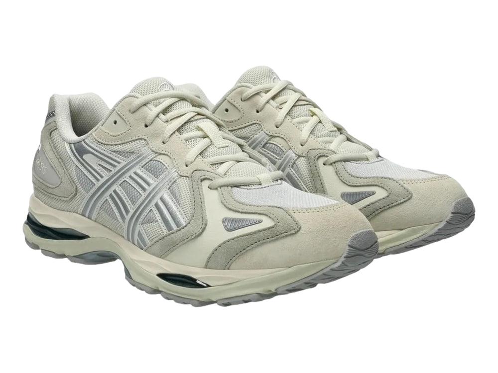 Tenis deportivos ASICS en color gris claro y blanco con suela amortiguada GEL.