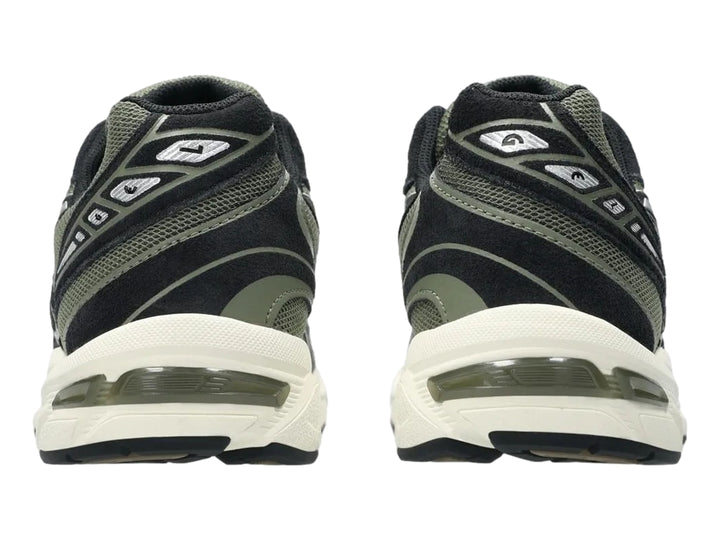 Tenis ASICS GEL-1130 color negro y verde oliva con suela blanca hueso.