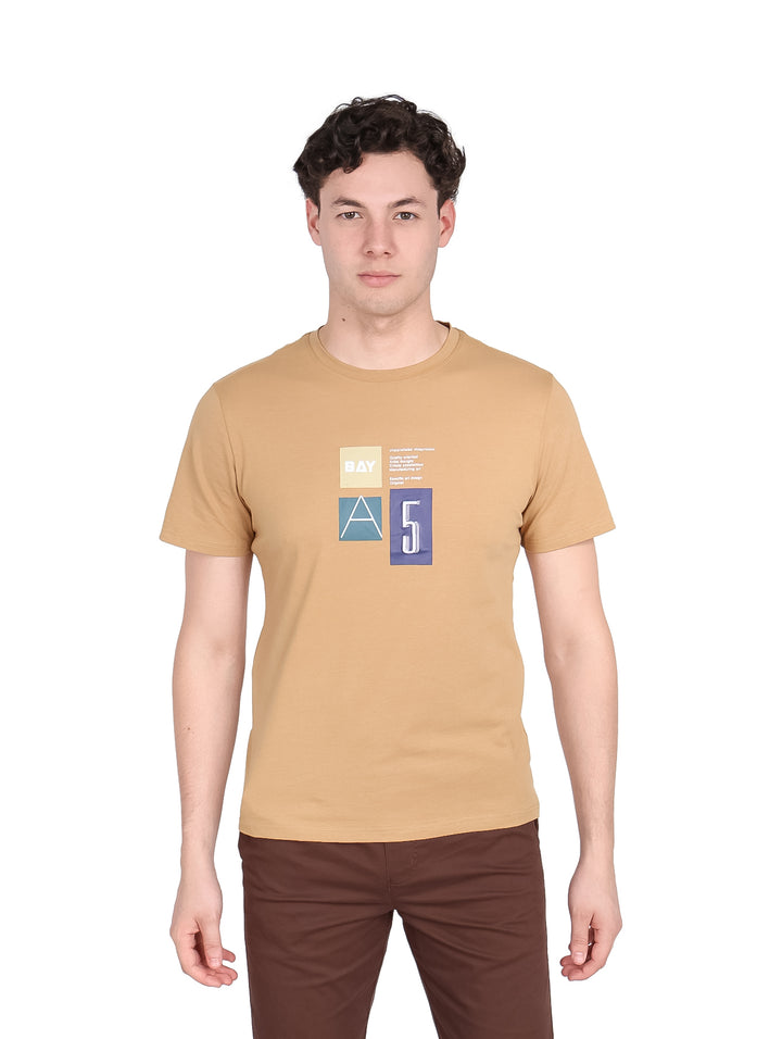 Hombre vistiendo playera de manga corta color café con estampado geométrico en el pecho.