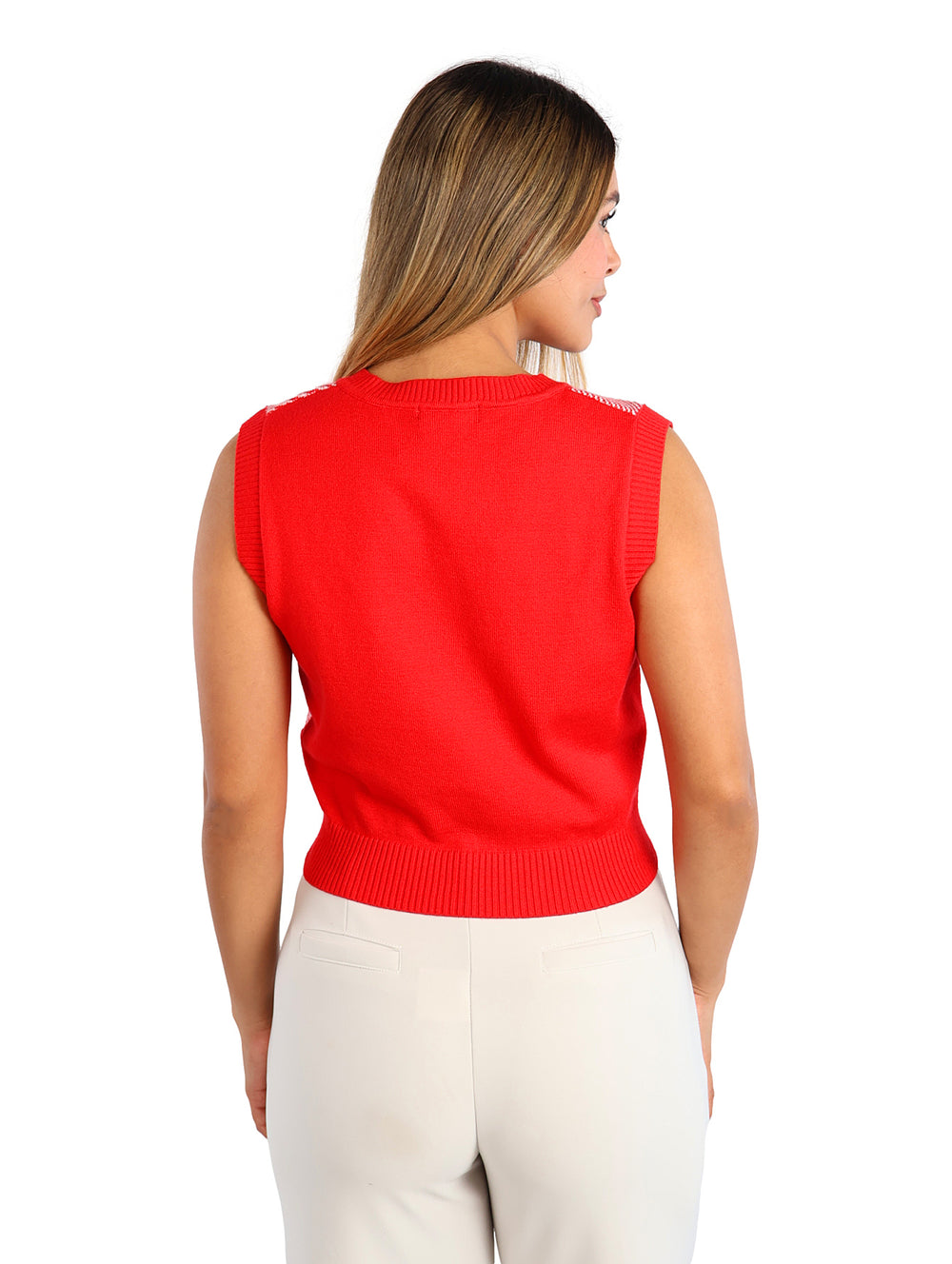 Mujer vistiendo un chaleco de punto rojo y blanco con estampado de cuadros y corazones, cuello en V.