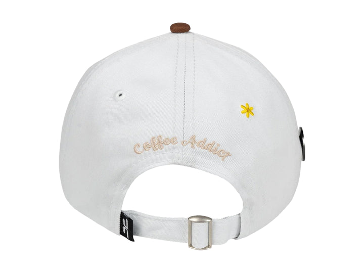 Gorra JC HATS color blanco con visera beige y bordado de una taza de café en el frente.