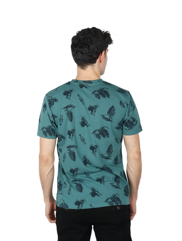 Hombre vistiendo playera verde de manga corta con estampado gráfico en color negro.