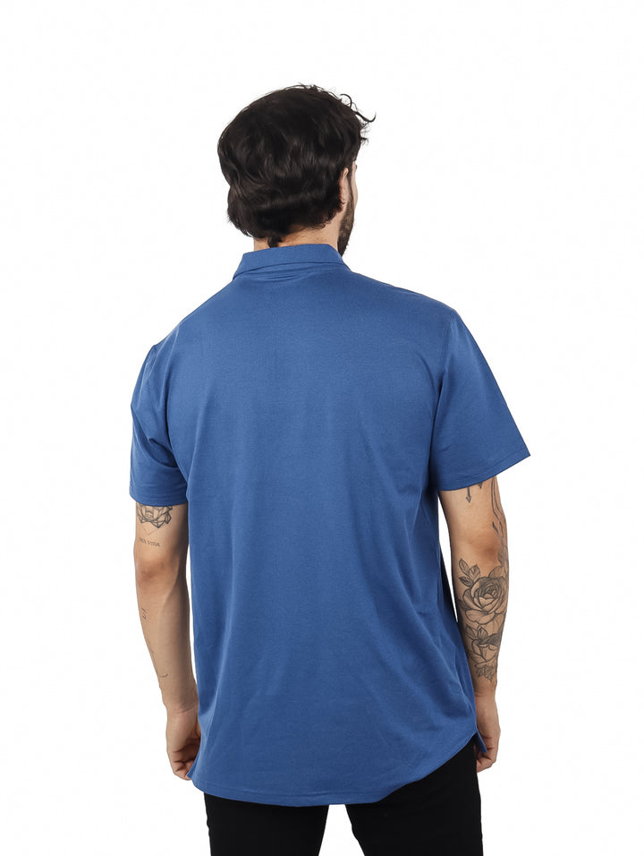Hombre vistiendo una camiseta polo azul de manga corta con bolsillo en el pecho.