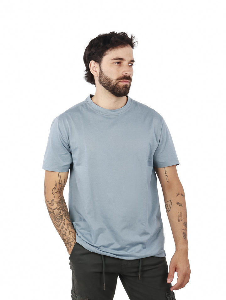 Hombre vistiendo una camiseta de manga corta color azul niebla con cuello redondo.