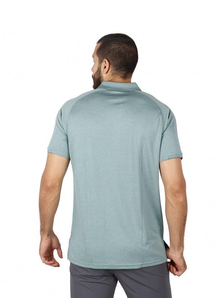Hombre vistiendo una camiseta polo de manga corta color verde grisáceo de la marca Eddie Bauer.