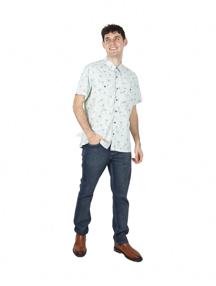 Hombre vistiendo camisa de manga corta color celadón con estampado sutil y botones frontales.