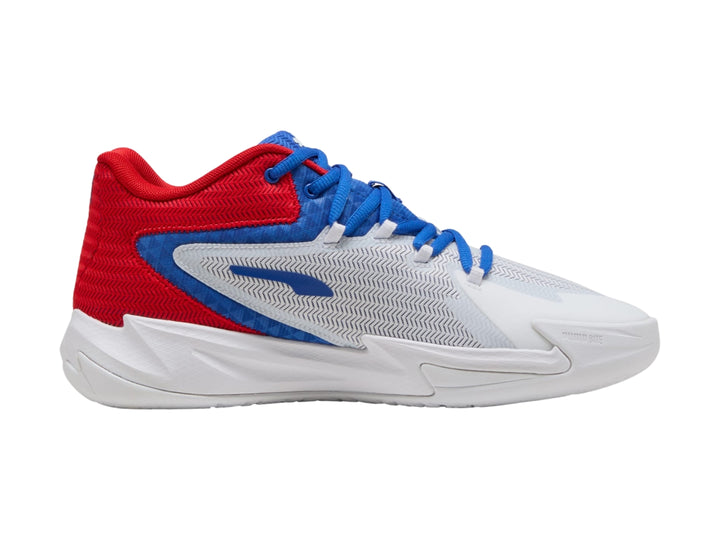 Tenis de baloncesto PUMA en colores blanco, rojo y azul con suela blanca y diseño moderno.