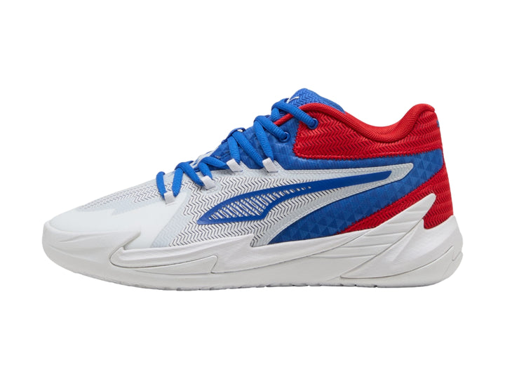 Tenis de baloncesto PUMA en colores blanco, rojo y azul con suela blanca y diseño moderno.