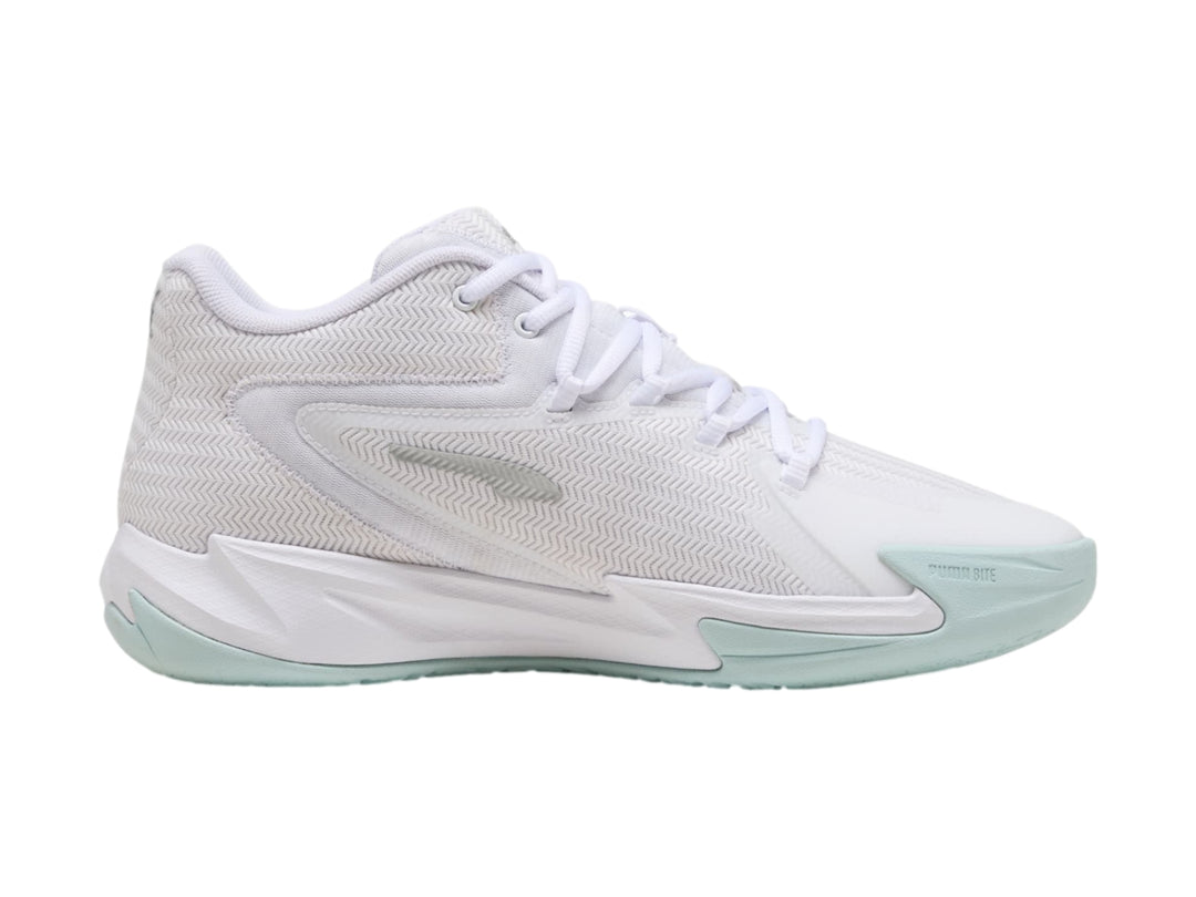 Tenis de baloncesto PUMA color blanco con detalles en plata y suela en tono azul claro.
