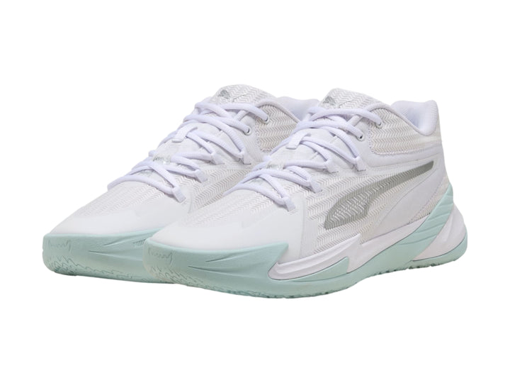 Tenis de baloncesto PUMA color blanco con detalles en plata y suela en tono azul claro.