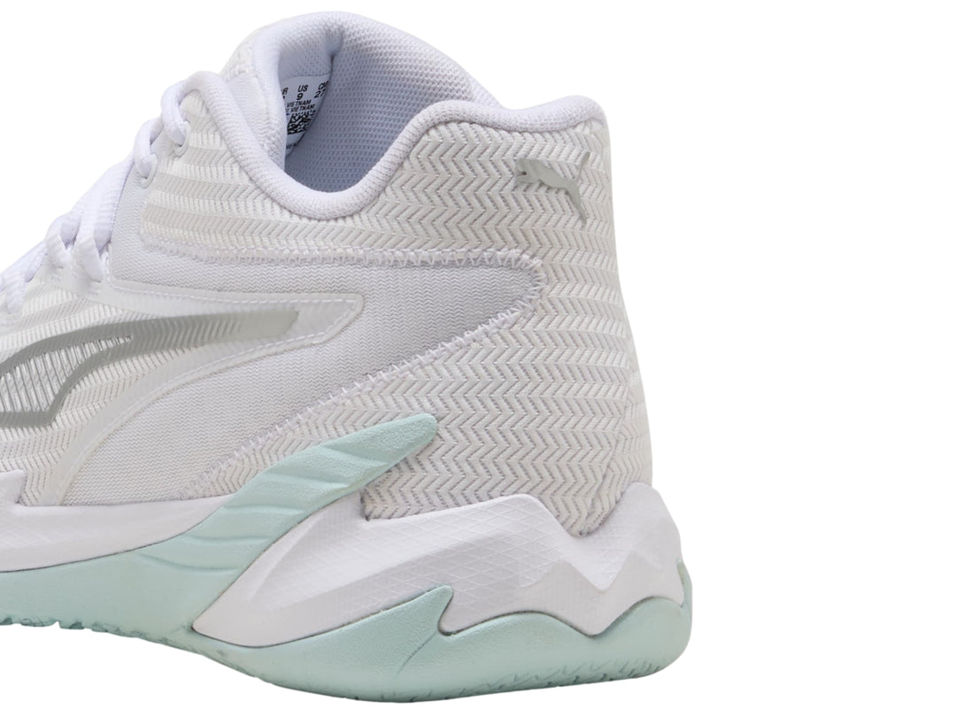 Tenis de baloncesto PUMA color blanco con detalles en plata y suela en tono azul claro.