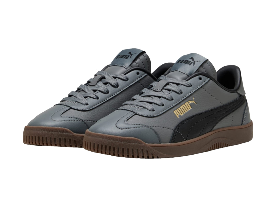 Tenis PUMA infantiles color gris oscuro con franja negra y suela color café.