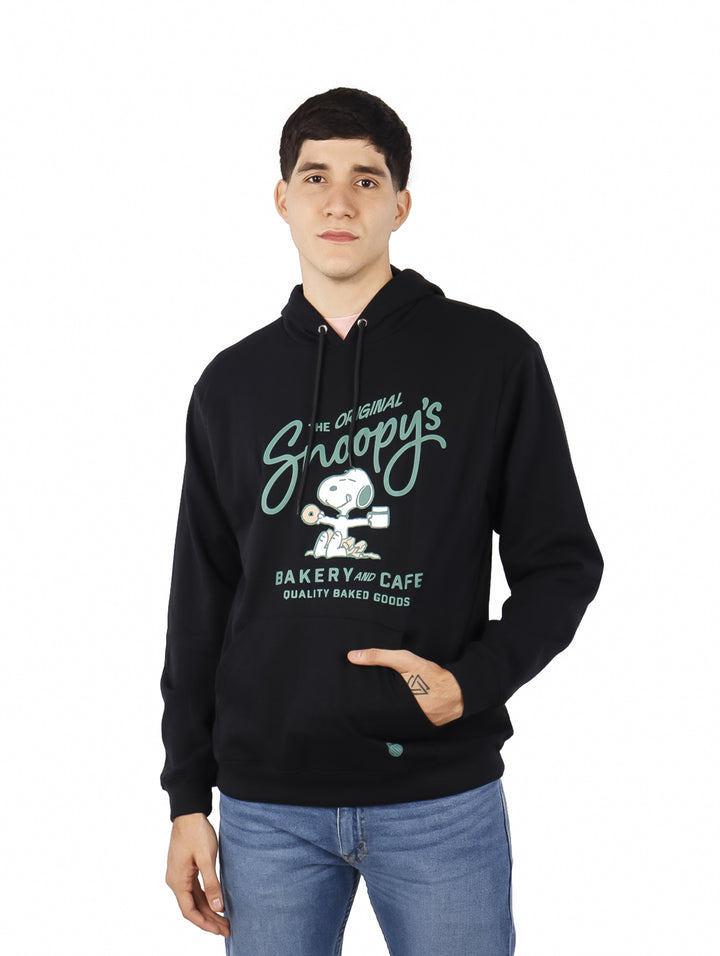 Hombre vistiendo sudadera con capucha color negro con estampado de Snoopy Bakery and Cafe en el pecho.