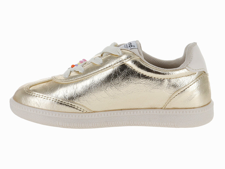 Tenis infantiles color oro metálico con adornos de cuentas y flores en los cordones y suela blanca.