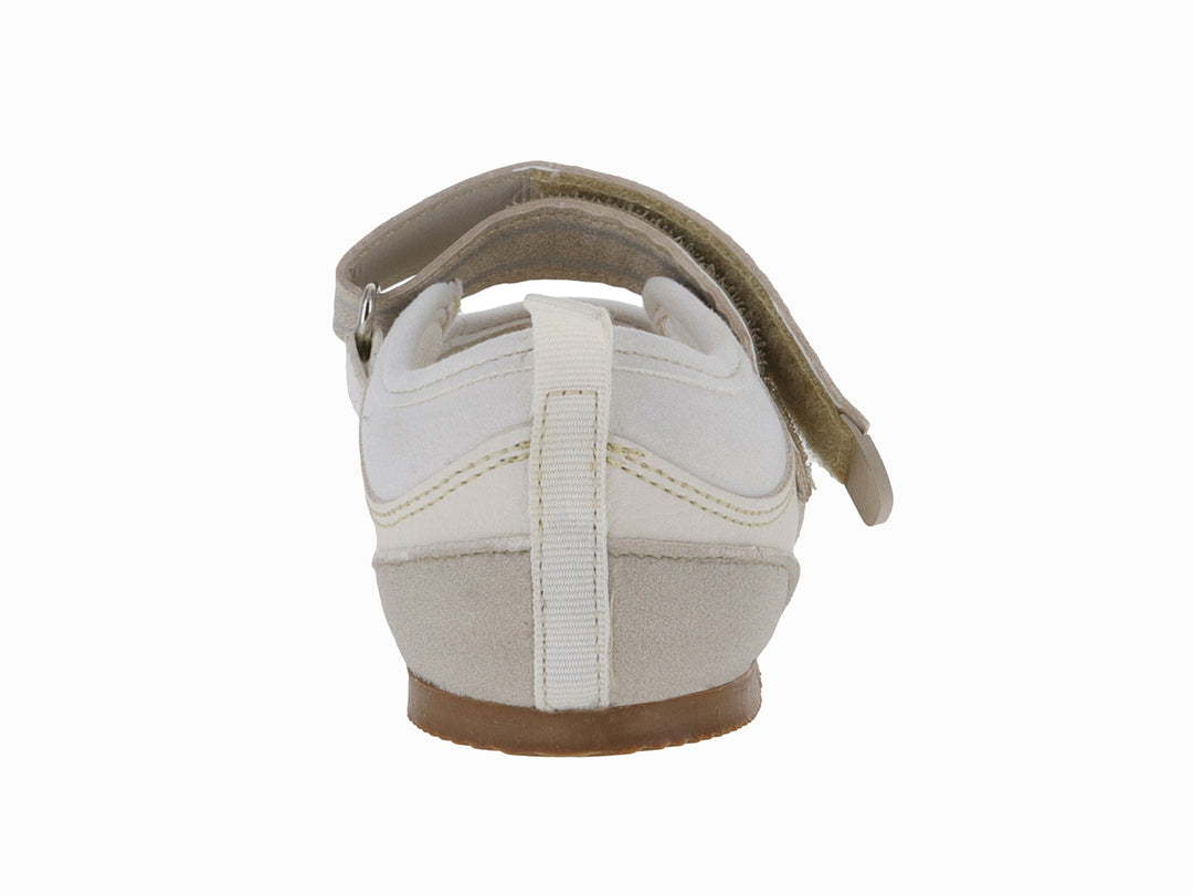 Zapato deportivo color beige con correa de velcro y suela color café.