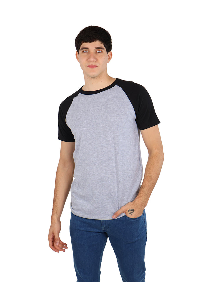 Hombre vistiendo playera de manga corta estilo raglan en colores gris y negro.